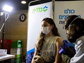 Mladá ena dostává vakcínu v Izraeli.