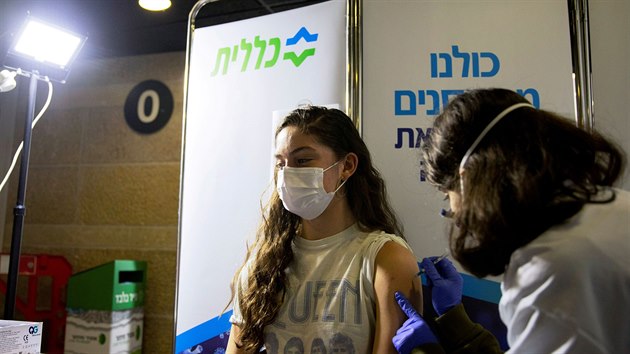 Mladá žena dostává vakcínu v Izraeli.