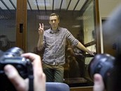 Alexej Navalnyj pózuje fotografm zpoza sklenného boxu u soudu v Moskv.