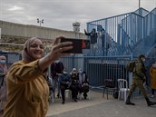 Zdravotníci okují Palestince na checkpointu mezi Ramalláhem a Jeruzalémem....