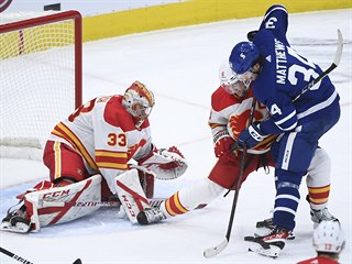 Obrnce Calgary Mark Giordano (uprosted) vytlauje hre Toronta Austona...