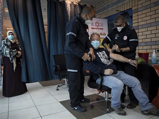 Zdravotnci okuj Palestince na checkpointu mezi Ramallhem a Jeruzalmem....