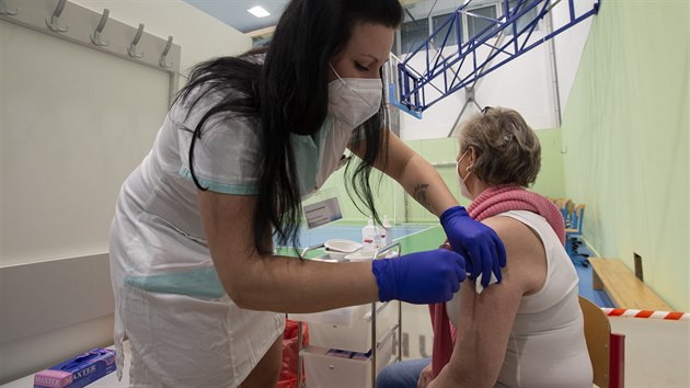 Zdravotnice očkuje klientku v očkovacím centru ve sportovní hale v Říčanech u...
