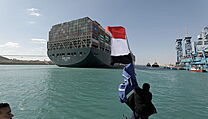 Muž s egyptskou vlajkou slaví vyproštění lodi Ever Given.