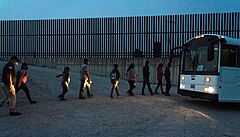 Rodiny �adatel� o azyl v USA nastupují do autobusu pohrani�ní strá�e poté, co...