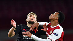 Slávista Jan Kuchta (vlevo) sleduje mí� v souboji s protihrá�em z Arsenalu.