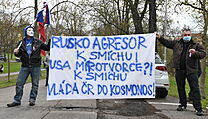 Demonstranti s transparentem ped budovou velvyslanectv Rusk federace v Praze...