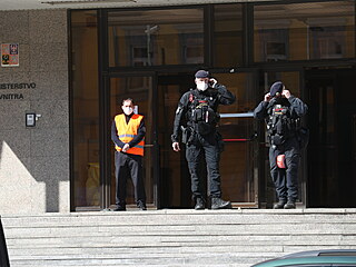 Policist ped ministerskou budovou.