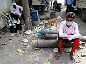 FILE PHOTO: Sumit Kumar, 28, sits on an oxygen cylinder as he waits outside a...