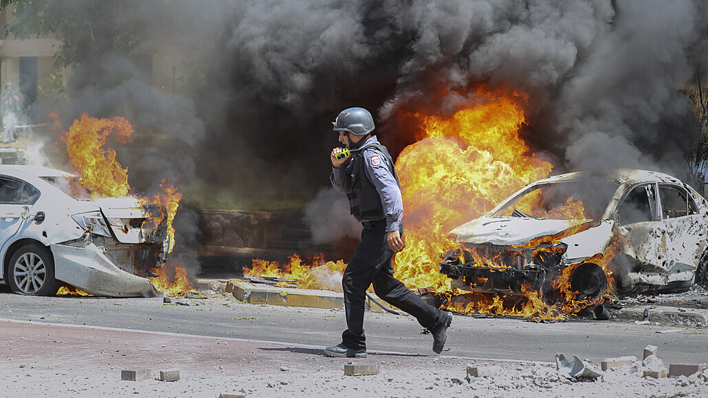 Izraelský hasič v hořících ulicích města Ašketon.
