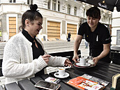 Servírka pináí objednávku zákaznici na restauraní zahrádce v centru Brna,...