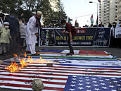 Lidé pálí vlajky Izraele, USA a Indie na podporu Palestiny.