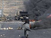 Palestinský protestující vyuívá prak.