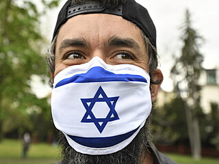 Stoupenec Izraele s roukou v barvch izraelsk vlajky sleduje v Praze...