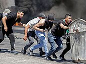 Protestující Palestinci se kryjí ped izraelským vojskem.