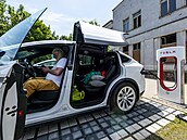 idi nabíjí elektromobil Tesla v dobíjecí stanici v centru Lovosic na...