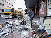 Dobrovolník pomáhá uklízet nepoádek po výtrnostech. Nepokoje v Jihoafrické...
