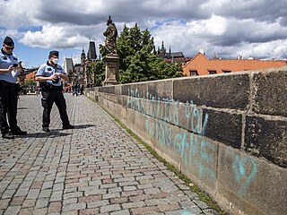 Policist dokumentuj posprejovn Karlova mostu v Praze.