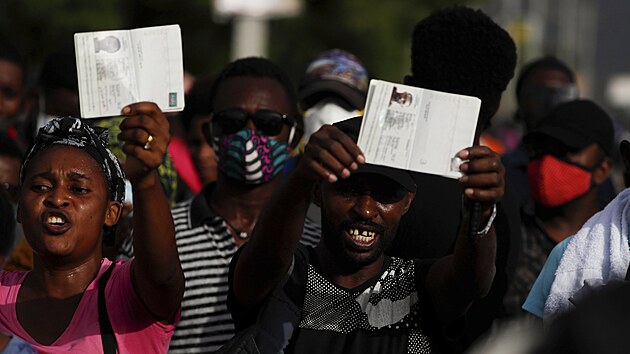 Lidé mávají pasy ped americkou ambasádou na Haiti.
