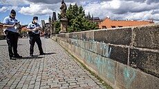 Policisté dokumentují posprejování Karlova mostu v Praze.