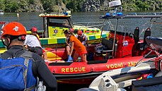 Záchranáři pomáhají lidem, kteří na Slapech narazili s lodí do skály