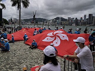 Pročínští aktivisté drží vlajky Číny a Hongkongu během oslav 25. výročí...
