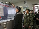 Ruský oficír kontroluje teplotu odvedených rekrut v náborovém centru ve...