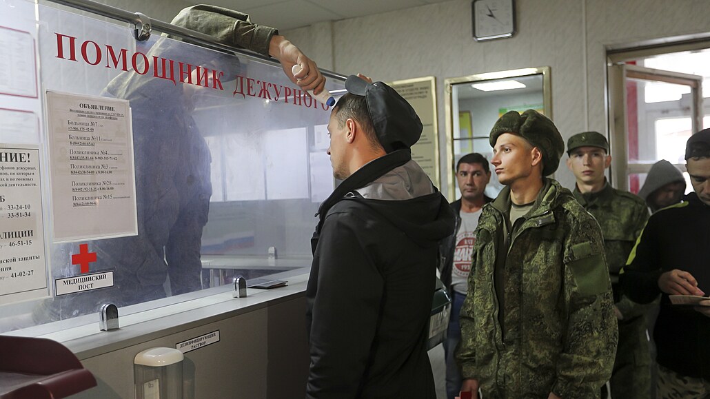Ruský oficír kontroluje teplotu odvedených rekrutů v náborovém centru ve...