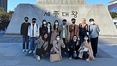 Pokro�ilí studenti �e�tiny u sochy krále Sed�onga.