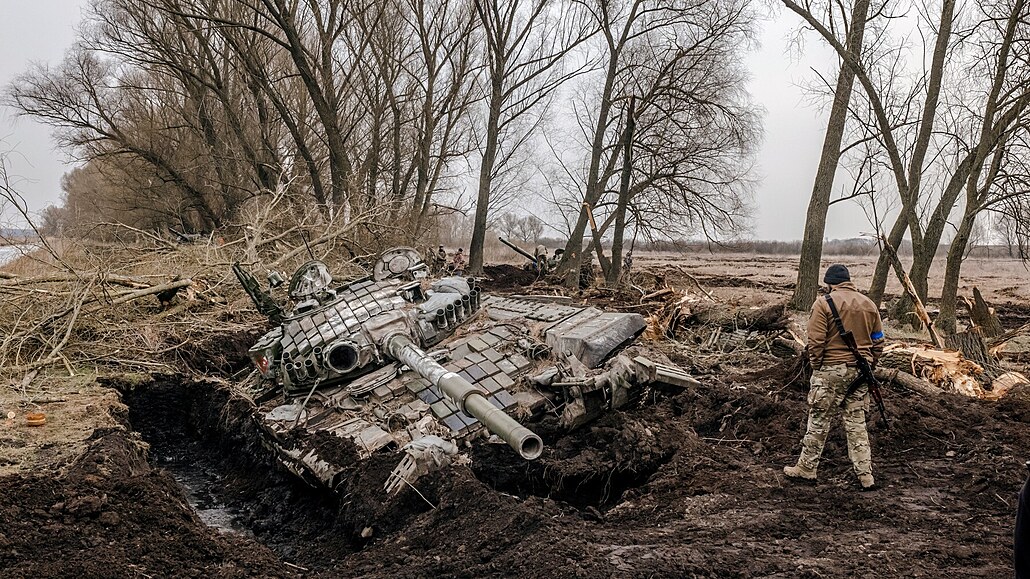 Ukrajinský voják kouká na ruský tank, který zstal v blát.