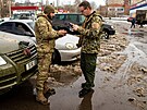eský dobrovolník (vlevo) pedává zásilku ukrajinskému vojákovi ve mst v...