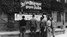 Němečtí občané čtou výtisk časopisu Der Stürmer (1935)