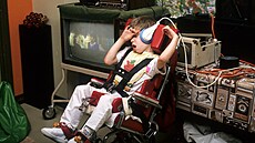 Chlapec připoutaný na invalidní vozík kvůli svalové dystrofii poslouchá hudbu.