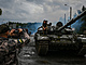 Ukrajinští vojáci se fotí na ruském tanku, který získali.
