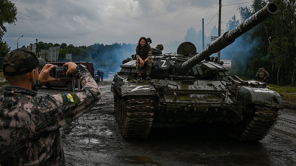 Ukrajintí vojáci se fotí na ruském tanku, který získali.