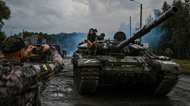 Ukrajintí vojáci se fotí na ruském tanku, který získali.
