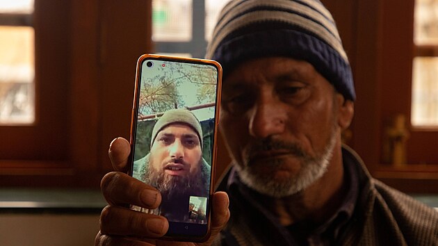 Indický otec ukazuje telefon, na kterém je snímek jeho syna v ruské armád.