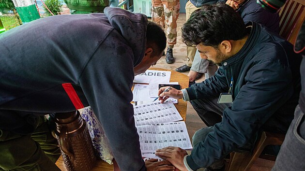 Mu hledá své jméno v seznamu voli ped volební místností v Banihal v Indii.