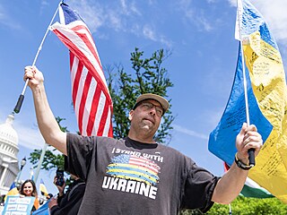 Demonstrant stojící ped Kapitolem, který podpoil financování Ukrajiny.