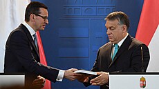 Ma�arský premiér Viktor Orbán (vpravo) dostává od svého polského prot�j�ku...
