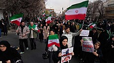 Lidé nesou íránské vlajky a provládní transparenty b�hem poh�ebního ob�adu...