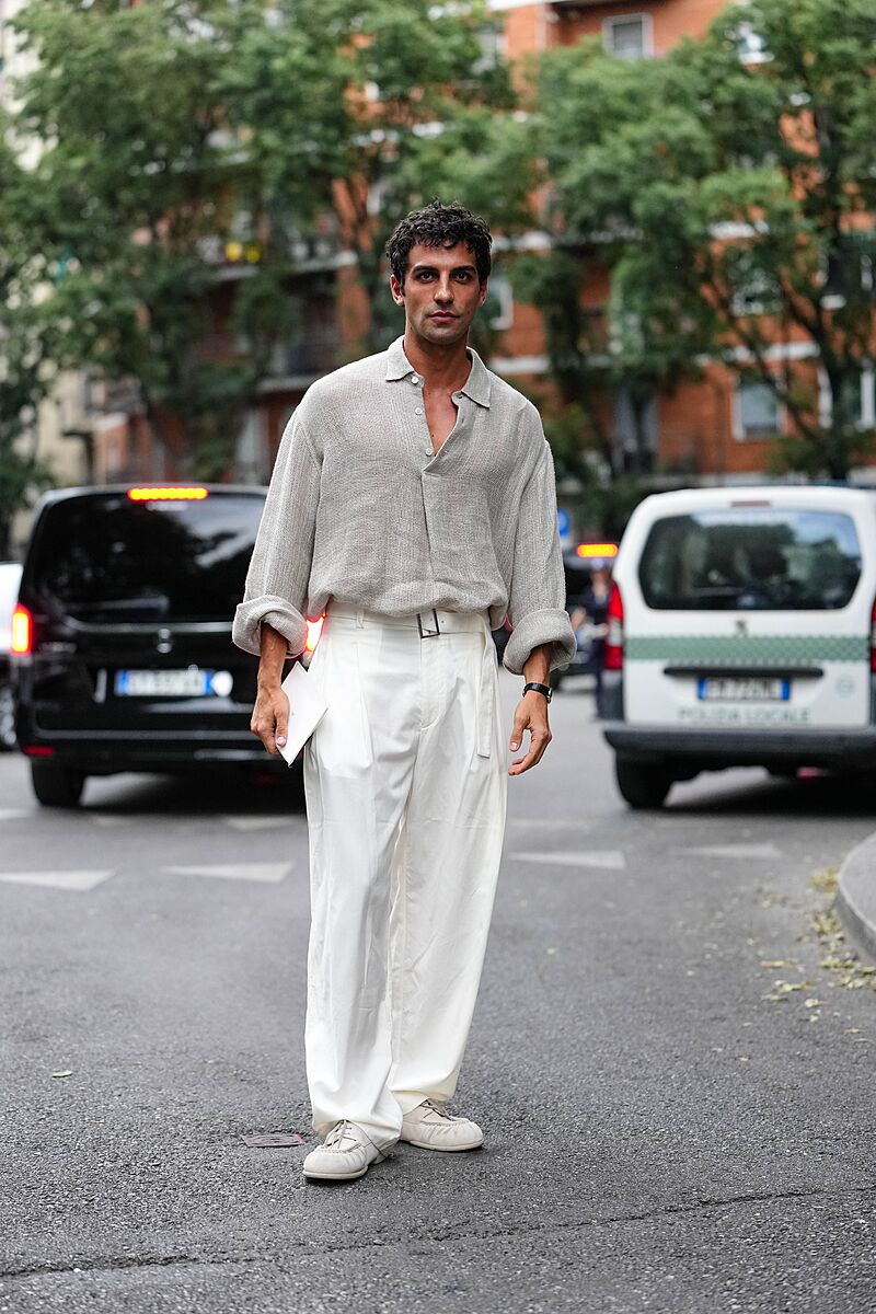 MILAN, ITALY - JUNE 21: A guest wears light gray sheer mesh buttoned up long...