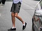 PARIS, FRANCE - JUNE 25:  A guest wears black shoes, shorts, and a blue and...
