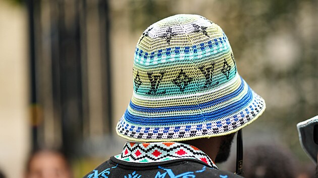 PA�͎, FRANCIE � 22. �ervna: Host m� na sob� �ern� polo tri�ko s neonov� modro-zelenou v��ivkou a bucket hat od Louis Vuitton s b�lo-modro-zelen�m pruhovan�m vzorem, �ern�m vy��van�m logem LV a potiskem. Sn�mek byl po��zen p�ed p�ehl�dkou AMIRI b�hem pa��sk�ho t�dne m�dy p�nsk�ch kolekc� jaro/l�to 2024 dne 22. �ervna 2023 v Pa��i ve Francii. (Foto: Edward Berthelot/Getty Images)