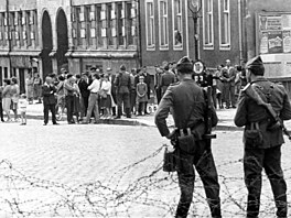 Dva východon�me�tí policisté sledují dav ob�an� z Východního Berlína.