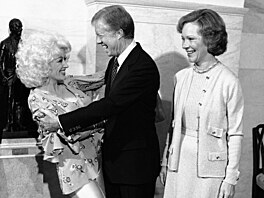 Americký prezident Jimmy Carter (uprost�ed) a Dolly Partonová (vlevo) se zdraví...