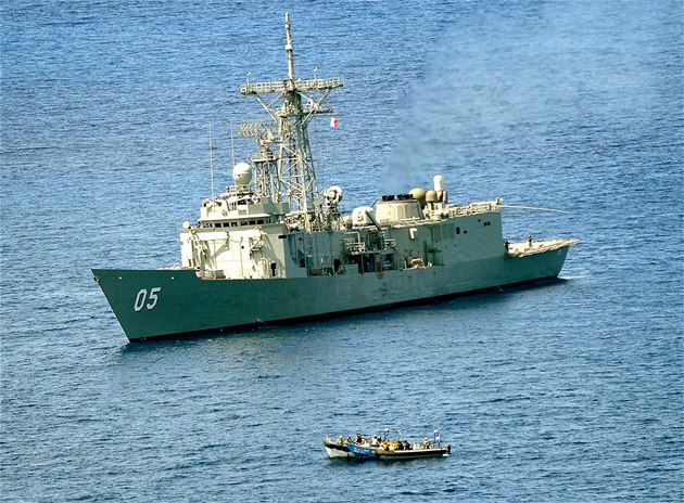 Australská válečná loď Melbourne připlouvá k člunům somálských pirátů