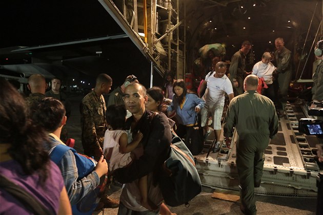 Evakuovaní Filipínci vystupují z amerického letounu na letišti v Manile