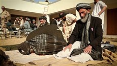 Afghánští muži se modlí v distriktním centru v provincii Hílmand, jehož cílem