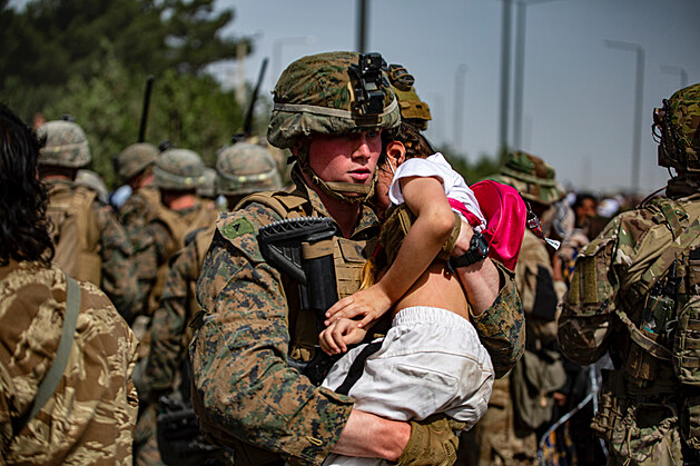 Příslušník americké námořní pěchoty přenáší afghánskou dívku od brány...